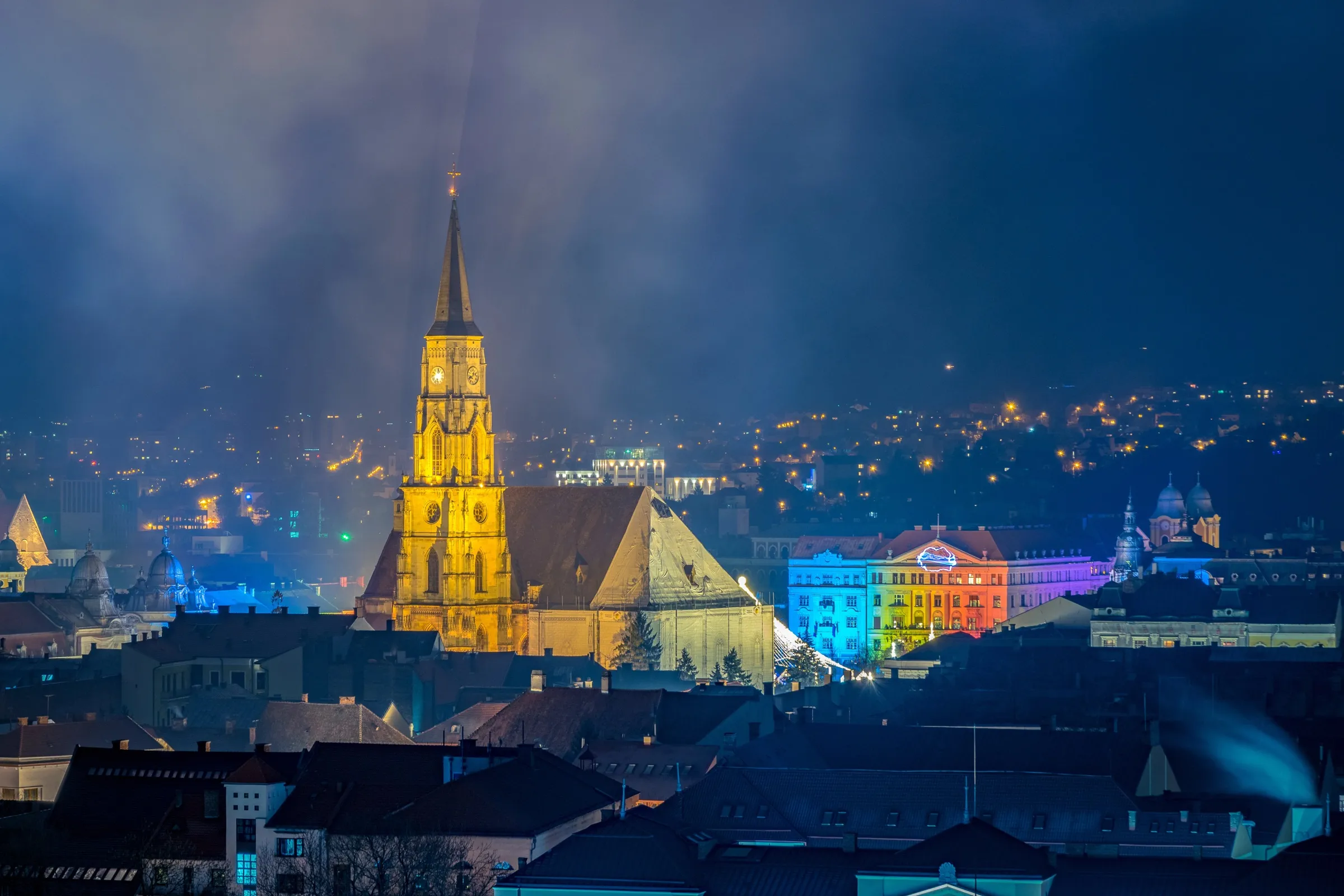 The old town of Cluj-Napoca at night, St Michael's Church lit above Unirii Square