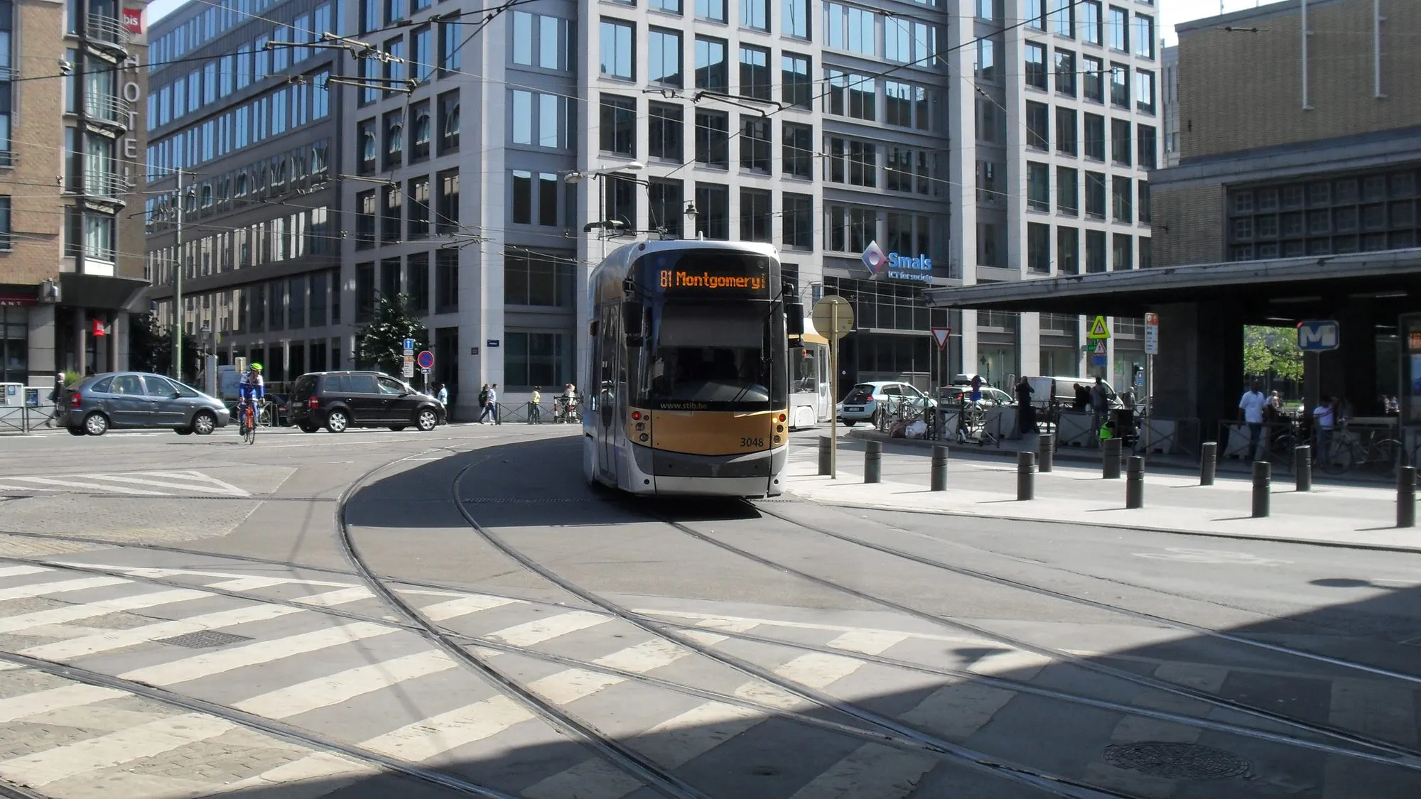 A Brussels T3000 tram on line 81 leaving the Gare du Midi stop, with office buildings behind it